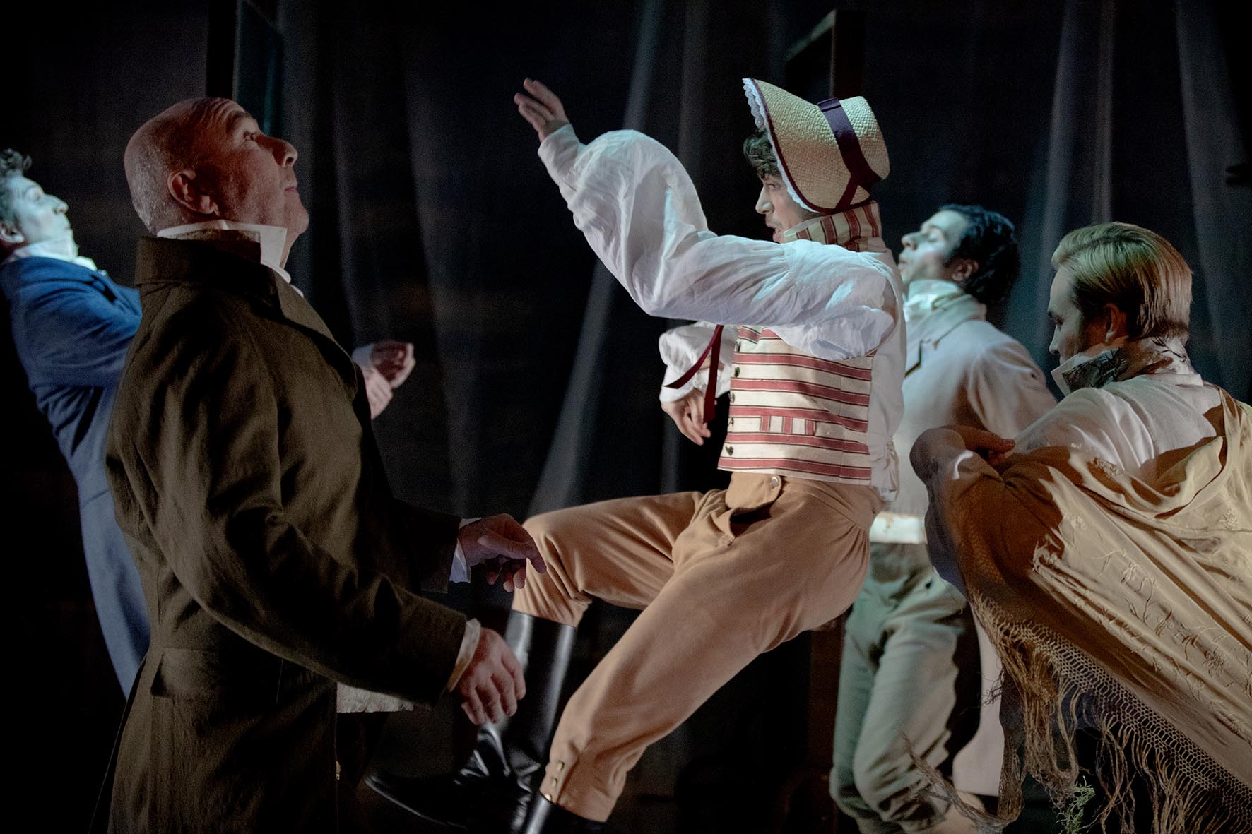 Promotion bild till Teater Hallands nytänkande uppsättning av Jane Austins Stolthet och Fördom. Fem män i georgisk kostym står i en vacker sal med äldre kristallkrona.