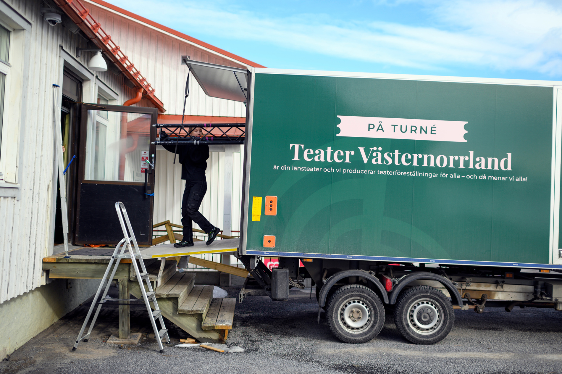 Scenarbetare bär kulisser inför föreställning när Teater Västernorrland är på turné.