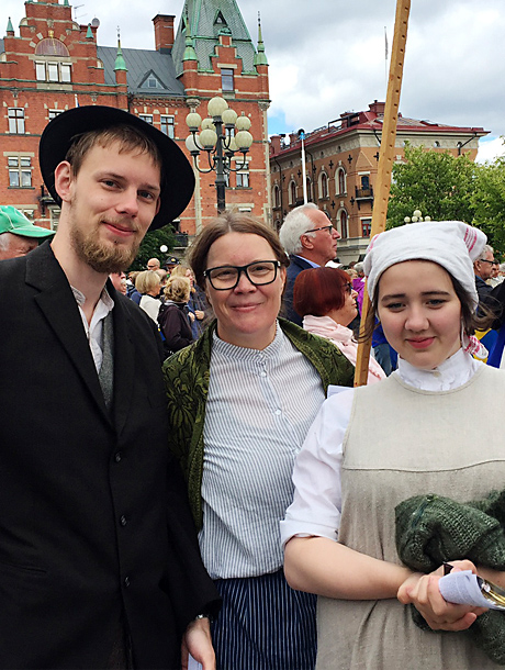 Ungdomar i kostym på torg inför teaterföreställning