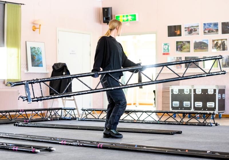 Ljustekniker fixar strålkastare inför teaterföreställning.