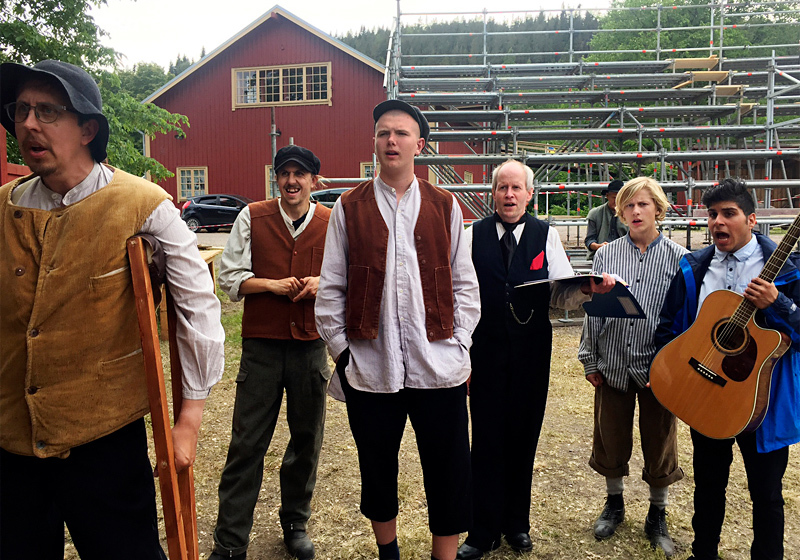 Amatörteatergrupp redo för utomhusföreställning på bygdegård.