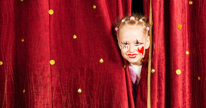 Affischbild för Familjedag på Teater Västernorrland. Ung flicka kikar fram genom en röd ridå.