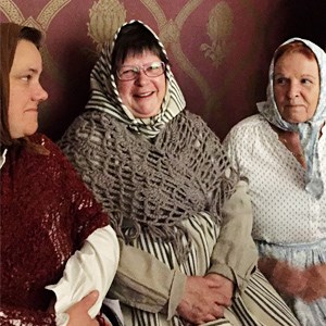 Kvinnor i gammeldags kostym inför amatörteater föreställning