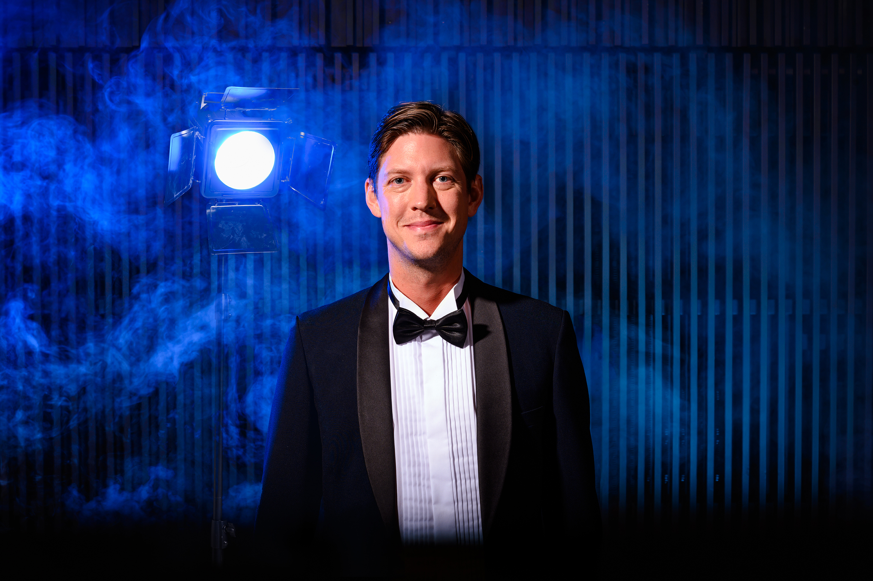 Teaterchefen Kristoffer Berglund uppklädd i frack med spotlight bakom.